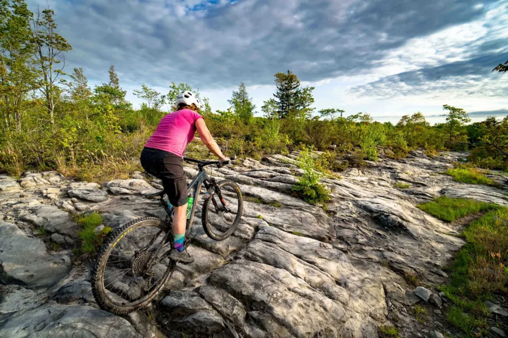 Woman riding across rocks on a mountain bike
