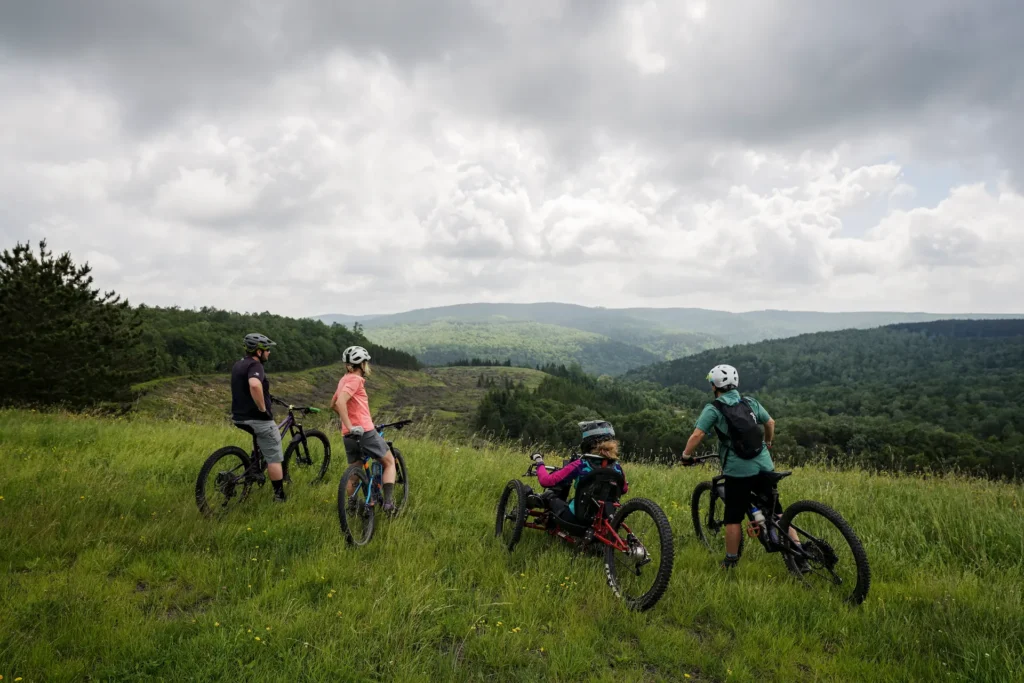View of mountain landscape with a group of riders gazing at the sunset